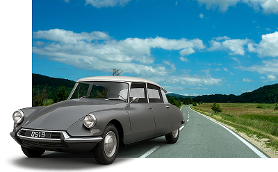 A Citroën DS19 car emerging from a road.